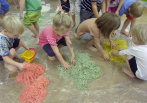 dzieci bawią się kolorowym makaronem