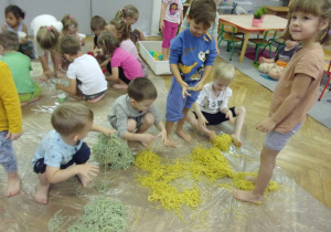 dzieci bawią się kolorowym makaronem
