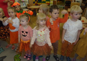 dzieci ubrane na pomarańczowo tańczą według instrukcji