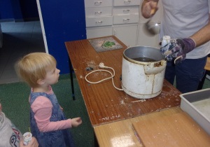 dziewczynka stoi podczas nalewania wosku