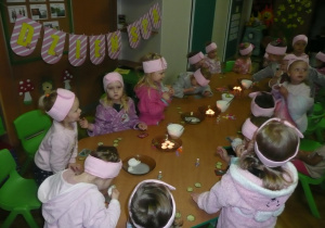 dziewczynki w szlafroczkach, opaskach na głowach maseczkach z ogórkami, w tle napis "Dzień SPA"