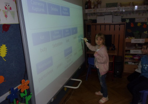 dziewczynka rozwiązuje zadanie na tablicy interaktywnej