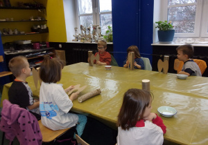 dzieci przy stole przykrytym żółtą folią