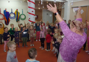 dzieci z podniesionymi rękoma na sali gimnstycznej