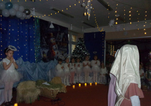 dziewczynki w strojach aniołków na tle dekoiracji świątecznej
