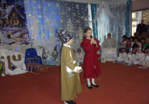 dziewczynka przebrana za Gerdę i chłopiec w roli Kaja na tle dekoracji z okazji Dnia Babci i Dziadka