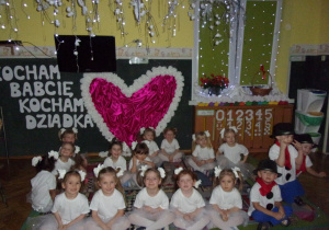 Tuptusie w klasie na tle dekoracji z okazji Dnia Babci i Dziadka