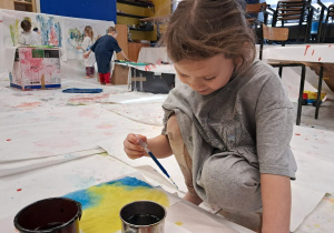 dziewczynka maluje pędzelkiem