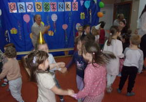 wspólny taniec dzieci ze wszytkich grup na sali gimnastycznej, w tle dekoracja urodzinkowa