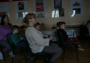 Juniorzy oglądają film na tablicy interaktywnej w Muzeum Tradycji Niepodległościowych