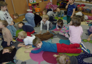 dzieci na dywanie wykonują omawiane ćwiczenia