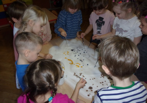 dzieci malują farbami na rozsypanej soli