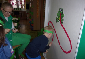 chłopiec przyczepia obrazki na języku żaby
