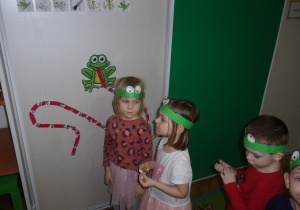 dziewczynki przyczepiają obrazki na języku żaby