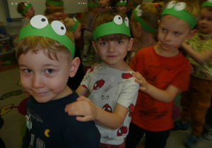 dzieci w opaskach żabek na głowie wykonują zadania opisywane przez nauczycielkę