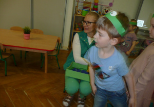 dzieci w opaskach żabek na głowie wykonują zadania opisywane przez nauczycielkę